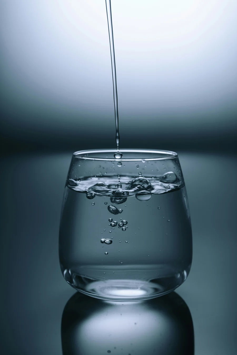 Vaso de agua llenándose desde el grifo